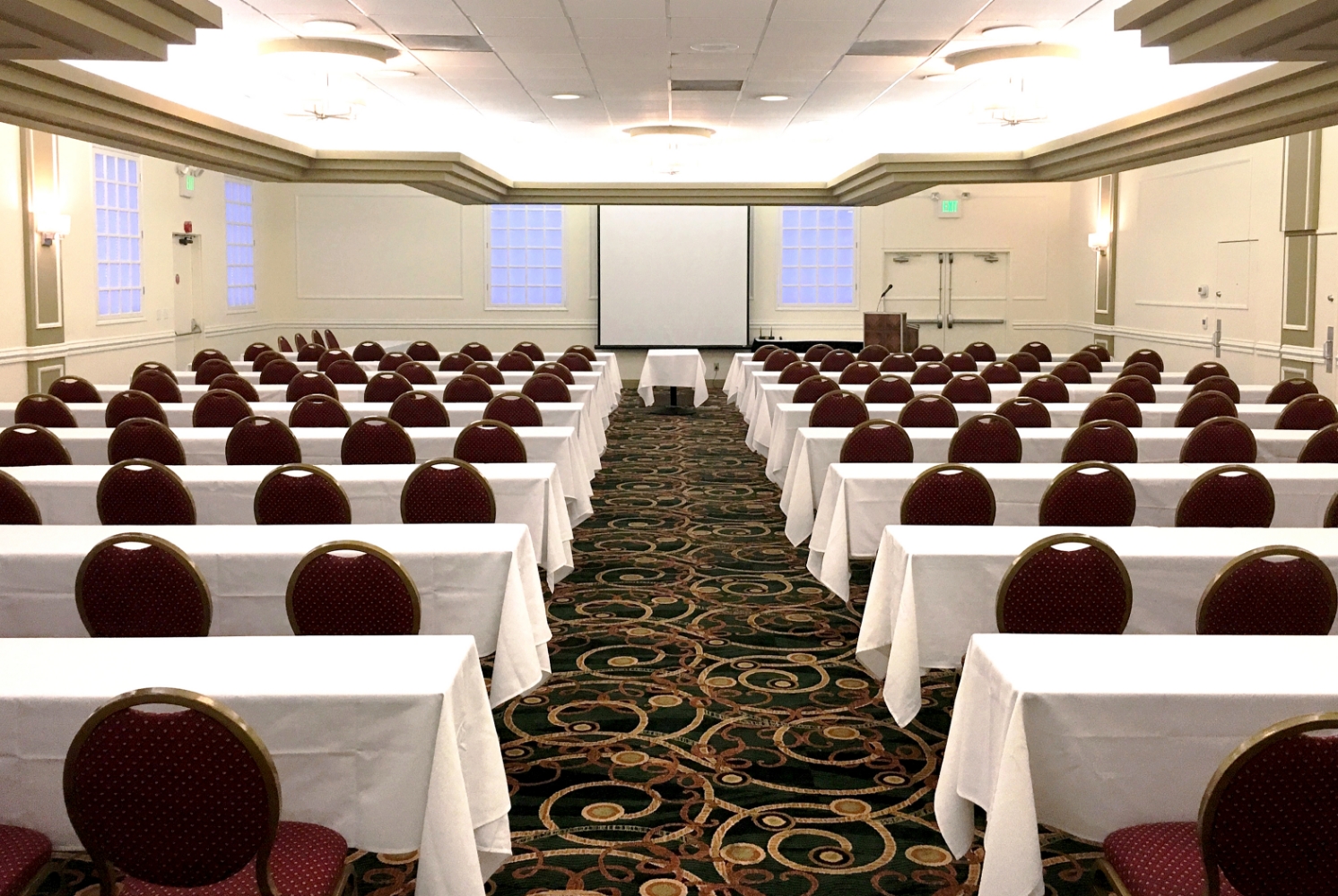 Ballroom set up in Classroom floor plan for up to 140 guests.